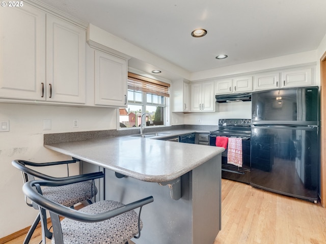 611 NW 4th Pl, Battle Ground, WA 98604 - kitchen with black appliances, under cabinet range hood, white cabinetry, a breakfast bar, and recessed lighting