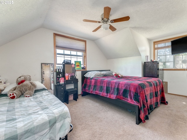 611 NW 4th Pl, Battle Ground, WA 98604 - bedroom featuring a textured ceiling, vaulted ceiling, multiple windows, carpet floors, and ceiling fan