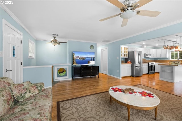 165 Lynn Ct, Winchester, OR 97495 - living area with wood finished floors, a ceiling fan, baseboards, and crown molding
