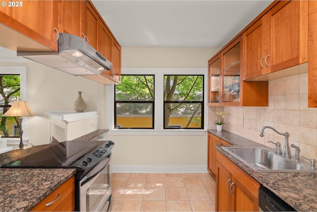 kitchen with stainless steel range with electric cooktop, a sink, brown cabinets, and backsplash