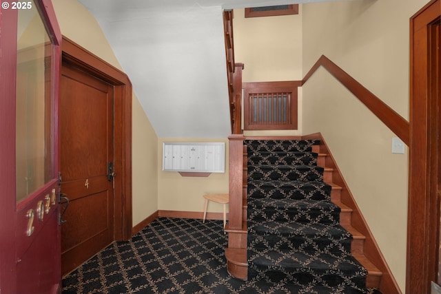 stairs featuring carpet, lofted ceiling, and baseboards