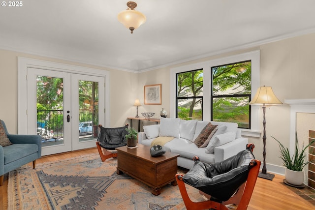 living room featuring healthy amount of natural light, french doors, wood finished floors, and ornamental molding