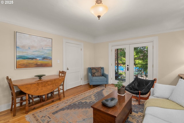 living area with wood finished floors, french doors, and baseboards