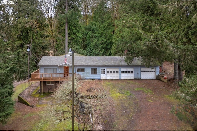 view of front of house featuring a deck, driveway, and an attached garage