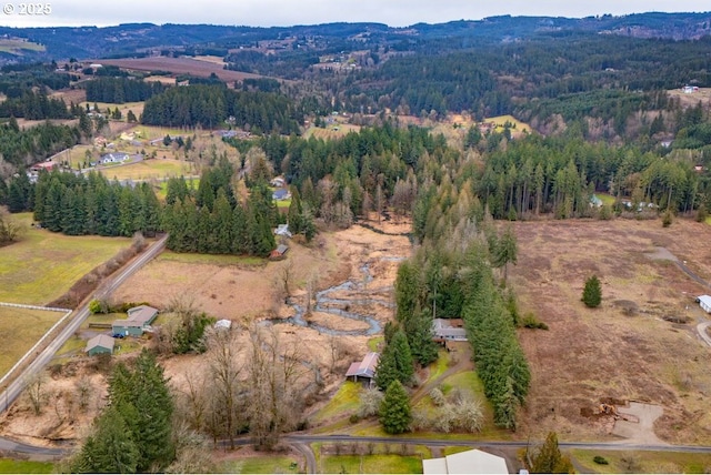 drone / aerial view with a mountain view and a forest view