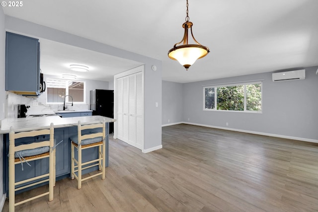 1500 Norkenzie Rd, Eugene, OR 97401 - kitchen with a wall unit AC, blue cabinetry, light countertops, and light wood finished floors