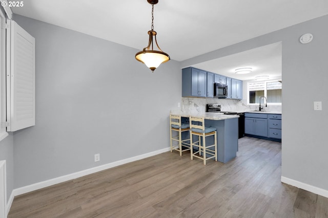 1500 Norkenzie Rd, Eugene, OR 97401 - kitchen featuring black microwave, blue cabinets, a kitchen bar, and a peninsula