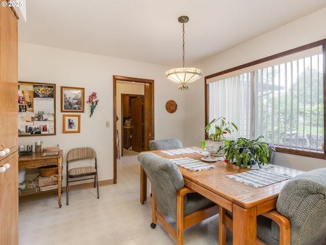 dining space featuring plenty of natural light, light flooring, and baseboards
