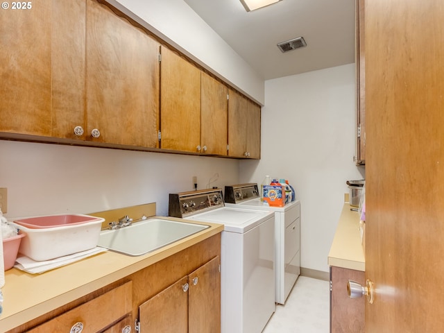washroom featuring cabinet space, washing machine and clothes dryer, and light floors