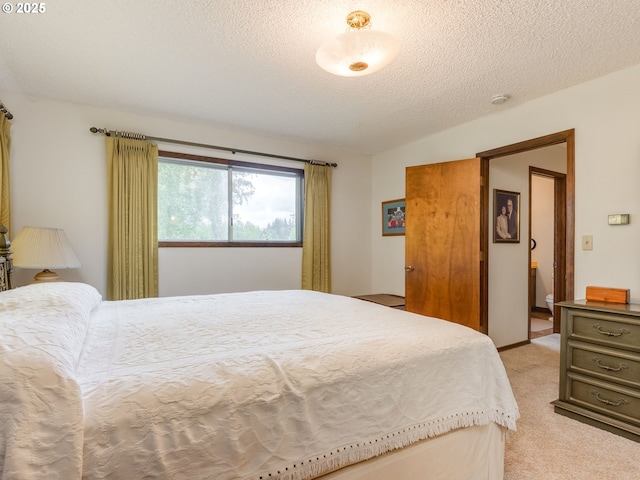 bedroom featuring light carpet and a textured ceiling