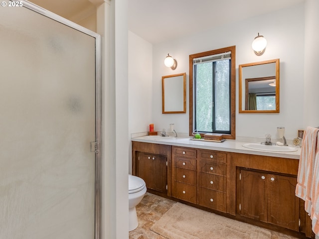 bathroom with a shower stall, double vanity, toilet, and stone finish flooring