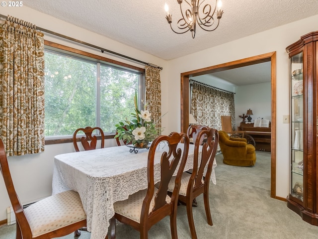 dining space featuring a chandelier, light colored carpet, plenty of natural light, and a textured ceiling