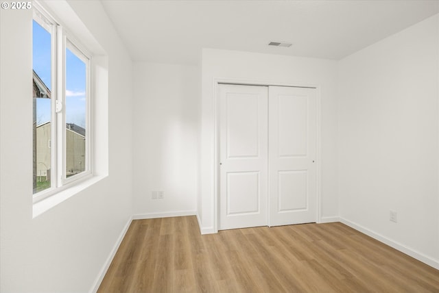 unfurnished bedroom with light hardwood / wood-style floors and a closet