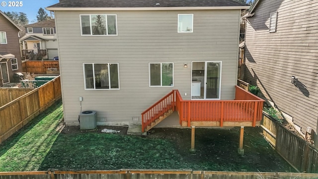 rear view of property featuring a yard and central air condition unit