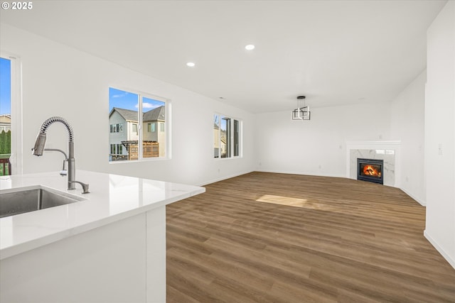 unfurnished living room featuring dark hardwood / wood-style flooring, sink, and a high end fireplace