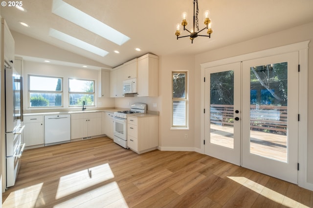 kitchen with white cabinetry, sink, white appliances, and french doors