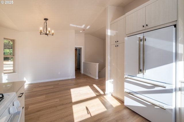 kitchen with white built in fridge, lofted ceiling, hanging light fixtures, and light wood-type flooring