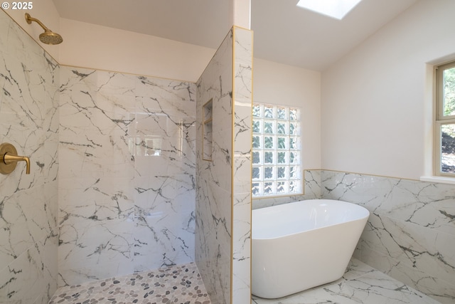 bathroom featuring shower with separate bathtub, tile walls, and a skylight