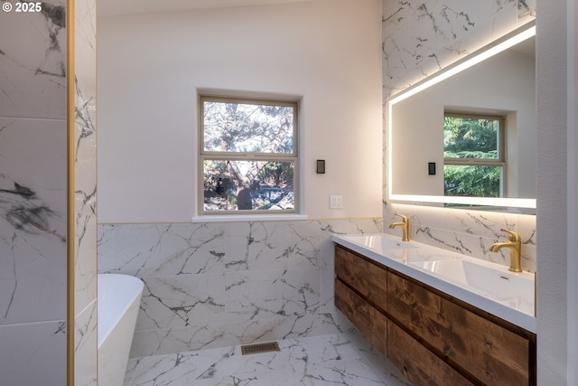 bathroom featuring tile walls, a bath, and vanity