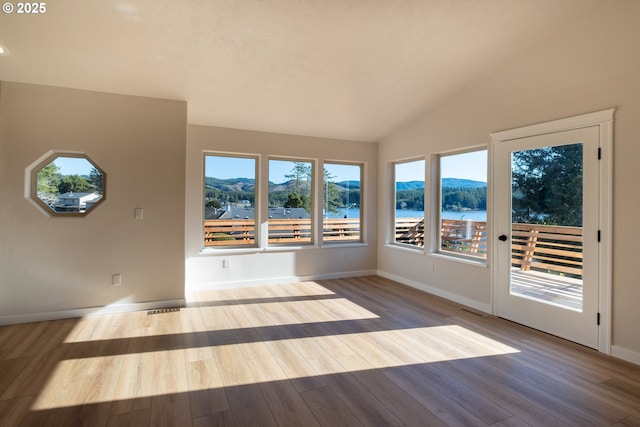 unfurnished sunroom with a water and mountain view and vaulted ceiling