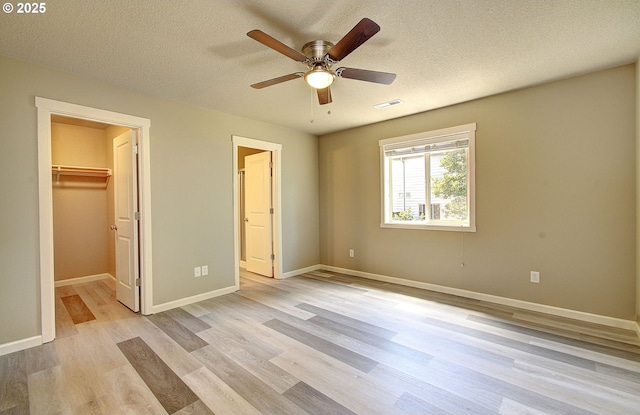 9513 NE 73rd St, Vancouver, WA 98662 - unfurnished bedroom featuring light wood-style floors, baseboards, a spacious closet, a textured ceiling, and a ceiling fan