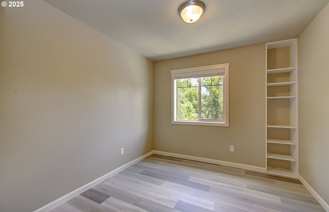 9513 NE 73rd St, Vancouver, WA 98662 - unfurnished room featuring light wood finished floors, a textured ceiling, baseboards, and built in features