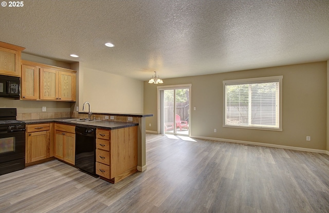 9513 NE 73rd St, Vancouver, WA 98662 - kitchen with black appliances, a peninsula, a sink, light wood-style flooring, and dark countertops