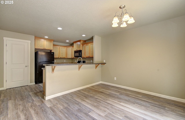 9513 NE 73rd St, Vancouver, WA 98662 - kitchen featuring black appliances, a kitchen breakfast bar, wood finished floors, baseboards, and recessed lighting