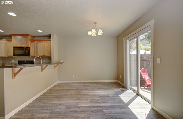 9513 NE 73rd St, Vancouver, WA 98662 - kitchen featuring black microwave, a breakfast bar, recessed lighting, light brown cabinets, and a chandelier