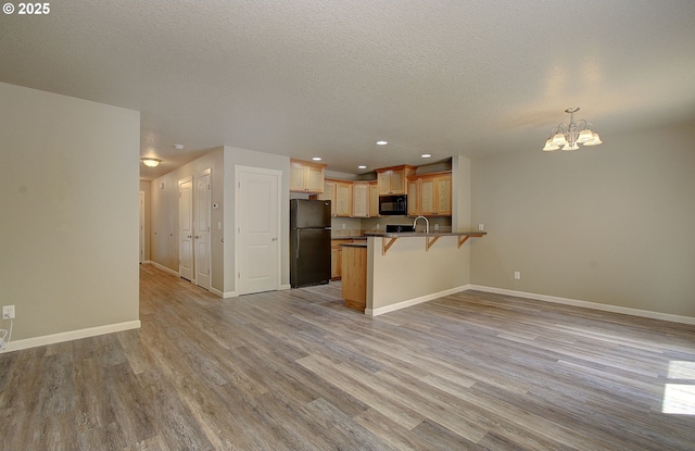 9513 NE 73rd St, Vancouver, WA 98662 - kitchen with black appliances, open floor plan, a breakfast bar, a chandelier, and a peninsula