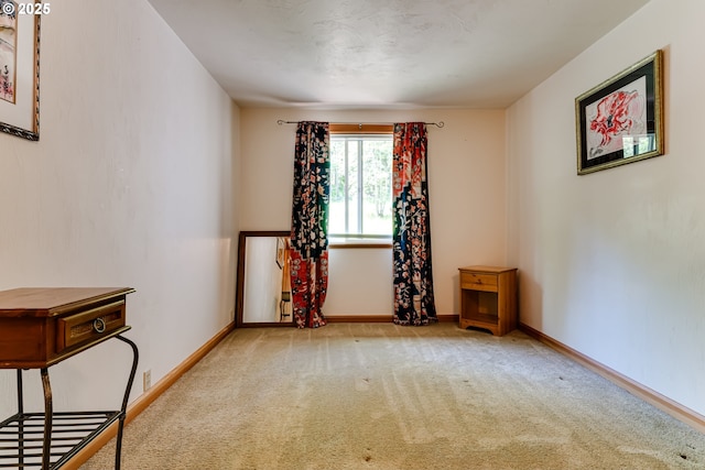 empty room with carpet and baseboards