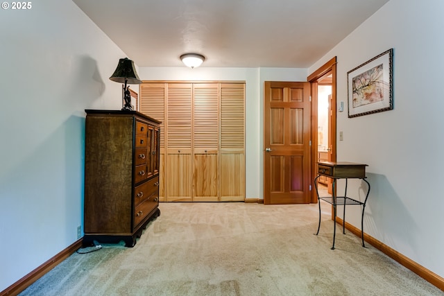 hallway featuring baseboards and light carpet