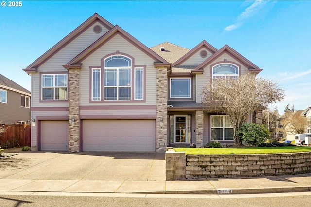 view of front of home with driveway, a garage, and fence