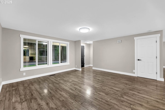 unfurnished room with dark wood-type flooring