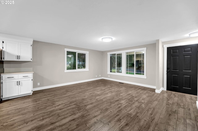 unfurnished living room with dark hardwood / wood-style flooring