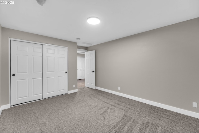 unfurnished bedroom with a closet and carpet flooring