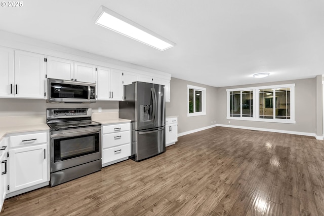 kitchen featuring stainless steel appliances, wood-type flooring, and white cabinets