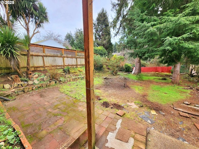 view of yard featuring fence and a patio