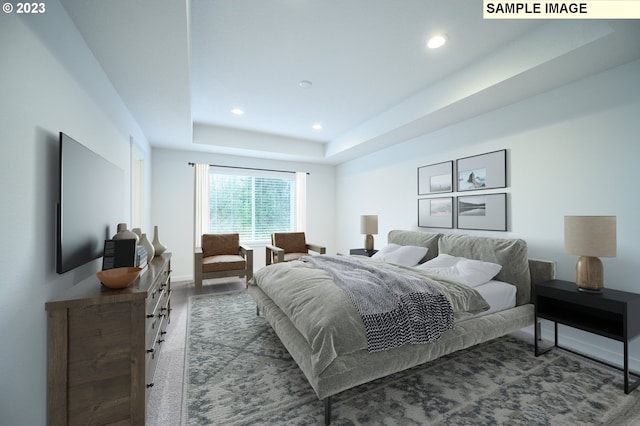 bedroom with recessed lighting, a tray ceiling, and baseboards