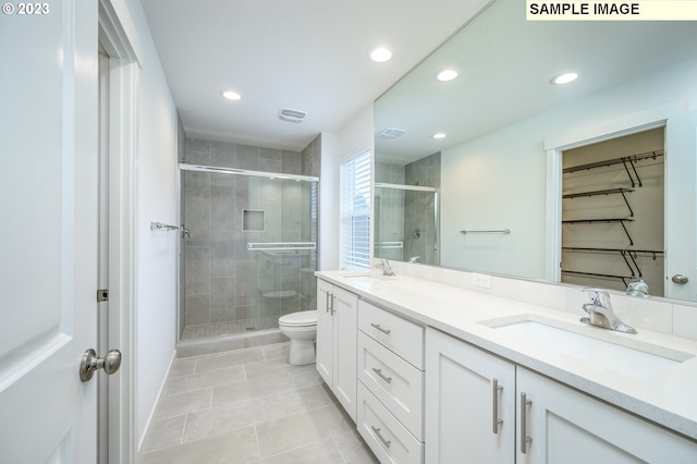 bathroom featuring a sink, toilet, a stall shower, and double vanity