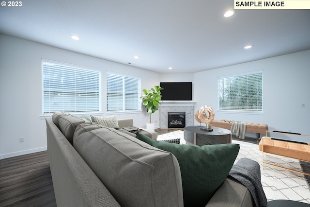 living room with recessed lighting, dark wood-type flooring, a healthy amount of sunlight, and a fireplace