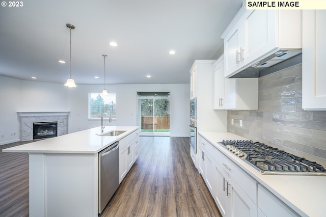 kitchen featuring dark wood-style floors, a sink, light countertops, appliances with stainless steel finishes, and tasteful backsplash