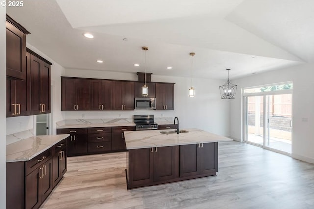 774 Riley Dr, Silverton, OR 97381 - kitchen featuring appliances with stainless steel finishes, light wood finished floors, dark brown cabinetry, light stone counters, and decorative light fixtures