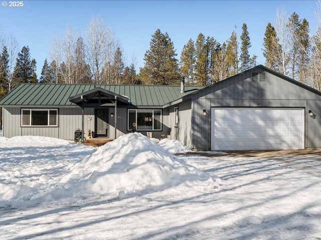 view of front facade with metal roof, a standing seam roof, and an attached garage