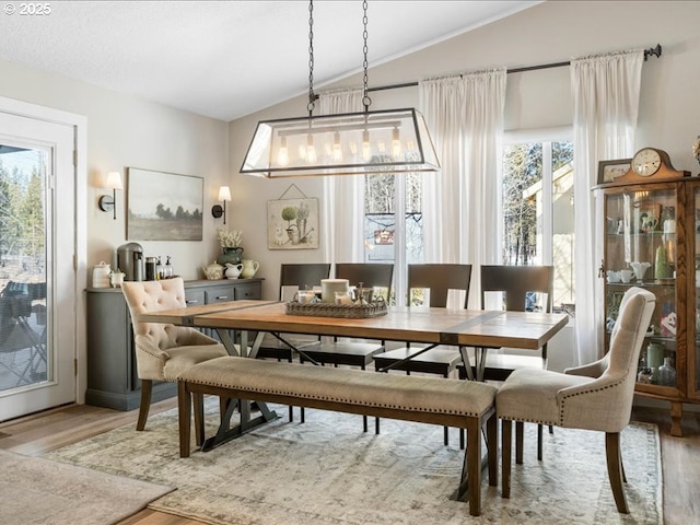 dining space featuring lofted ceiling and wood finished floors