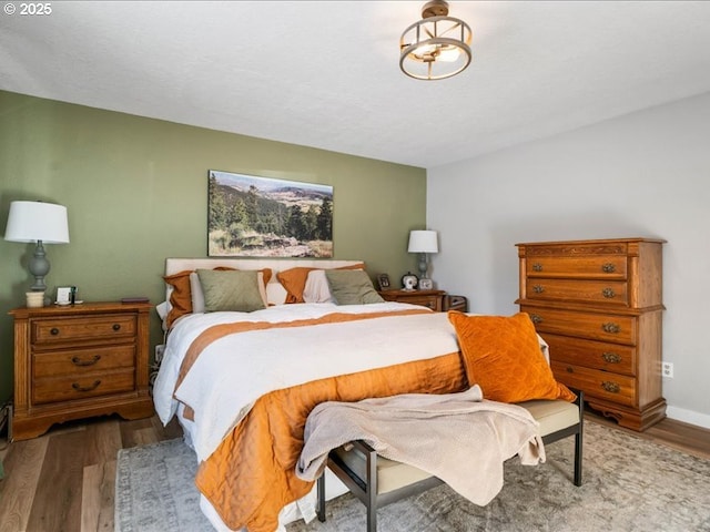 bedroom featuring dark wood-type flooring and baseboards