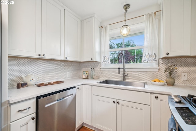 kitchen featuring stainless steel dishwasher, a sink, decorative backsplash, white cabinets, and hanging light fixtures