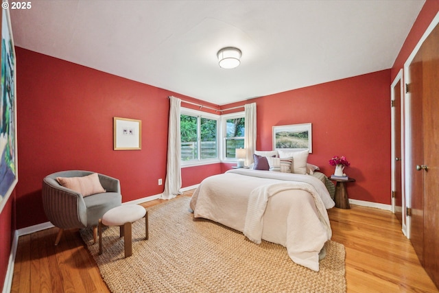 bedroom with light wood-type flooring and baseboards