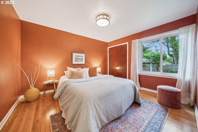 bedroom with baseboards and wood finished floors