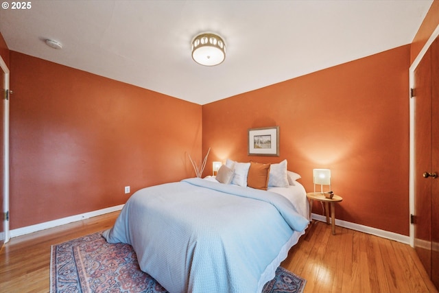 bedroom with baseboards and wood finished floors